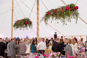 Pink and blue marquee wedding with hanging floral and festoon lights