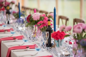Wedding banqueting tables in blue and pink with flowers and candles